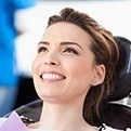 Smiling womn in dental chair after preventive dentistry treatment