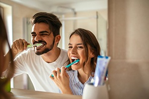 A couple brushing their teeth together after tooth colored filling restoration