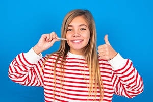 smiling teen girl in front of a blue background