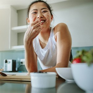 woman eating a snack in her kitchen