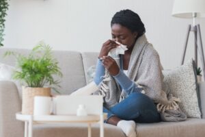 woman blowing her nose with the flu