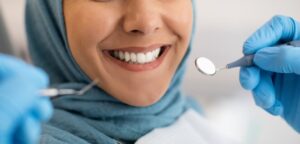 closeup of a woman’s beautiful smile with dental tools near her face